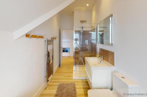 uma casa de banho com um lavatório e um espelho em WOOLACOMBE SUNNYSIDE APARTMENT 2 Bedrooms em Woolacombe