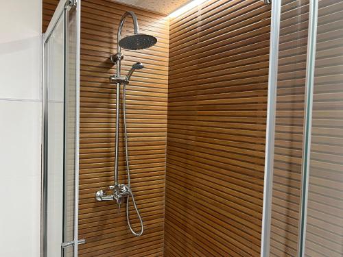 y baño con ducha y pared de madera. en Apartamento Ciudad Jardín con PARKING, en Córdoba