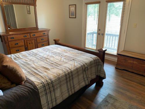 1 dormitorio con cama, tocador y espejo en Creek View Townhome, en Augusta