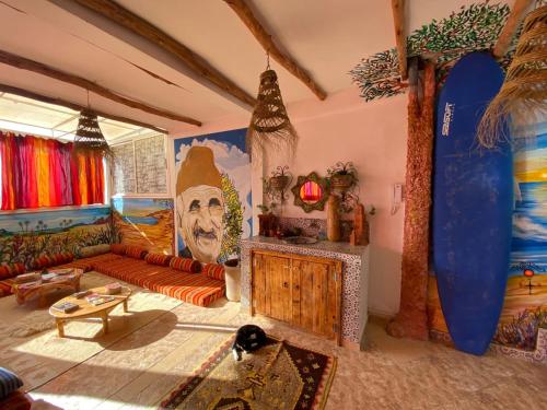 ein Wohnzimmer mit einem an der Wand gemalten Surfbrett in der Unterkunft Happy Surf Hostel in Taghazout