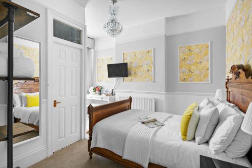 sypialnia z łóżkiem, telewizorem i lustrem w obiekcie Sandway House w mieście Torquay