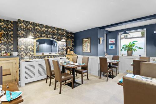 una sala da pranzo con pareti e tavoli blu e sedie di Sandway House a Torquay