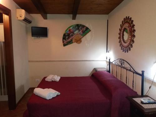 a bedroom with a bed with a red bedspread at APPARTAMENTO A SAN VITO LO CAPO STANZA CON BAGNO in San Vito lo Capo