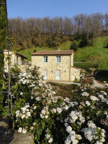 a stone house with flowers in front of it at Il Borghetto Andrea Tafi in Lamporecchio