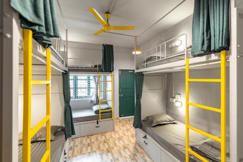 Ce dortoir comprend des lits superposés et un ventilateur de plafond. dans l'établissement Whoopers Hostel Anjuna, Goa, à Anjuna