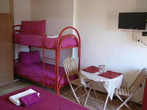 a room with a purple bunk bed and a table at monolocale tropea in Parghelia