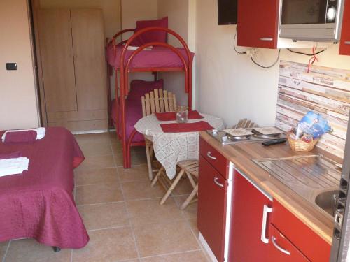 a small kitchen with a table and a bed at monolocale tropea in Parghelia
