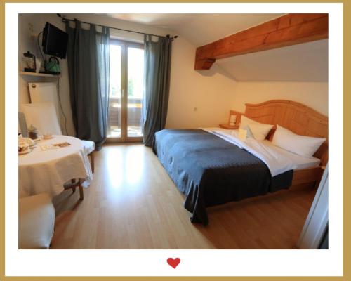 a hotel room with a bed and a table at Berghupferl - do legst di nieda in Oberaudorf