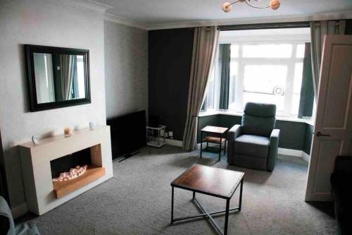 een woonkamer met een open haard en een stoel bij SL Luxury 3 Bedroom Home in Holly Lane