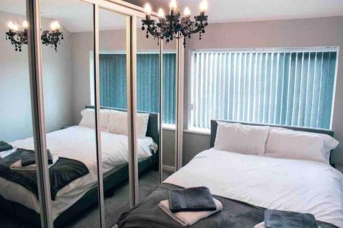 een slaapkamer met 2 bedden en een spiegel bij SL Luxury 3 Bedroom Home in Holly Lane