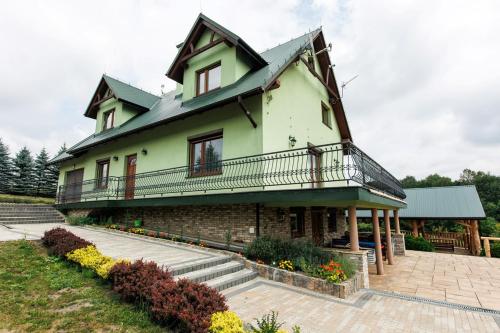 a large house with a balcony on top of it at Dolina 3 Stawów Tarnawka in Handzlówka