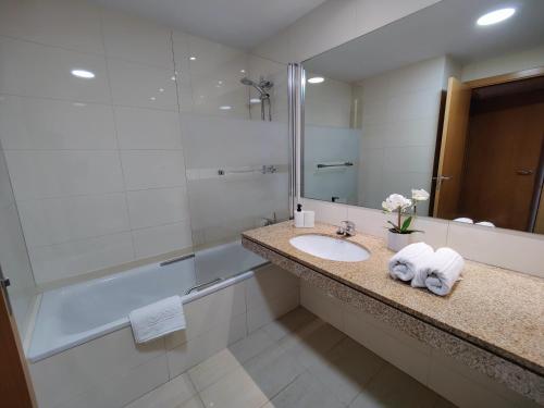 y baño con lavabo, ducha y espejo. en Badalona Beach Apartment en Badalona