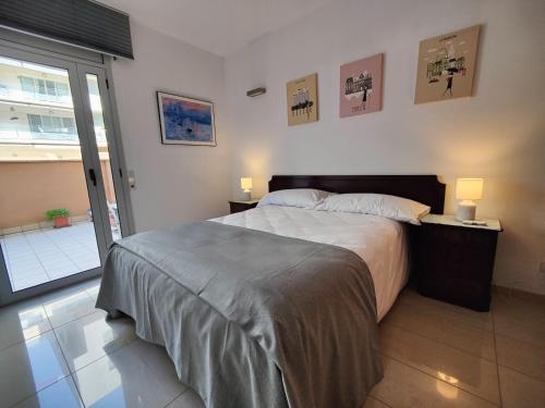 a bedroom with a large bed with two lamps on tables at Badalona Beach Apartment in Badalona