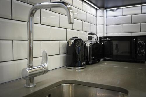 a kitchen counter with a sink and a faucet at Vibrant 2BR King Retreat - Parking, Gym & Wi-Fi! in Bedford