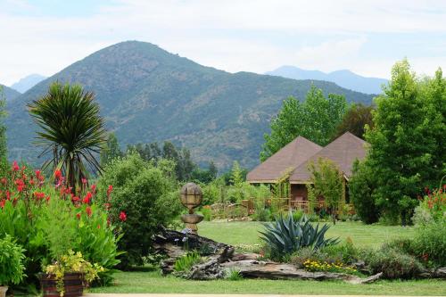 a garden with a house and mountains in the background at Mapuyampay Lodge Gastronómico in Santa Cruz