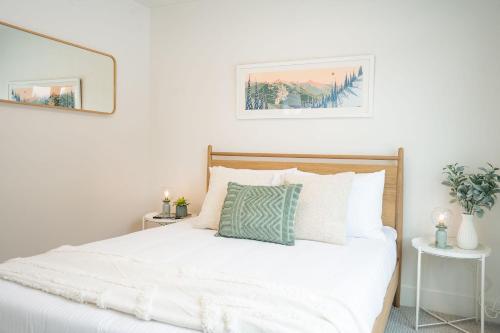 a bedroom with a white bed with a green pillow at Adanac by Revelstoke Vacations in Revelstoke