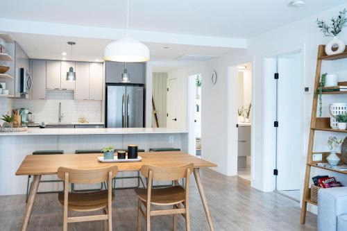 a kitchen and dining room with a wooden table and chairs at Adanac by Revelstoke Vacations in Revelstoke