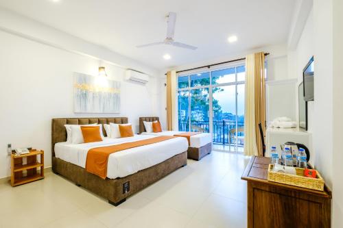 Habitación de hotel con 2 camas y balcón en Queens mount Ridge en Kandy