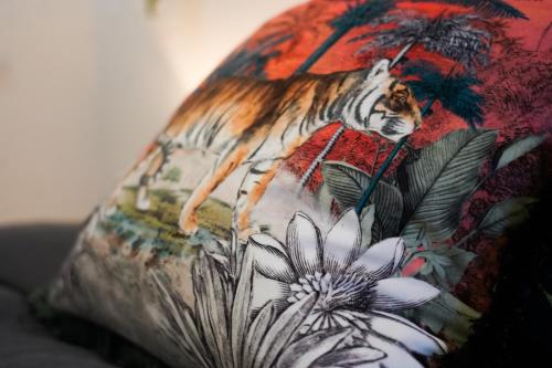 a pillow with a tiger on it with flowers at Vibrant 2BR King Retreat - Parking, Gym & Wi-Fi! in Bedford