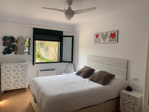 Un dormitorio con una gran cama blanca y una ventana en Mirador del Jerte, en Valdastillas