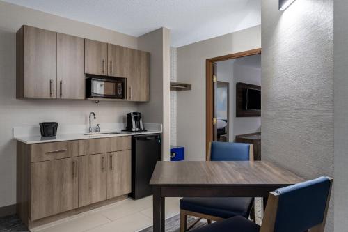 a kitchen and dining room with a table and chairs at Holiday Inn Express Hotel & Suites-St. Paul by IHG in Vadnais Heights
