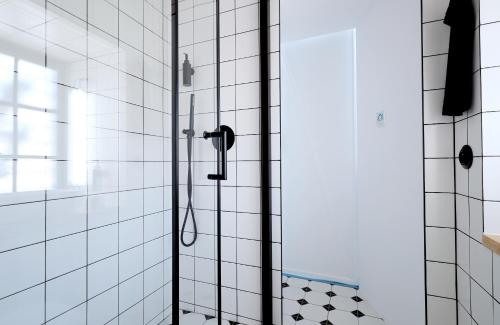 un bagno con doccia e piastrelle bianche di Trafajda a Lipnice nad Sázavou