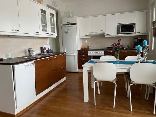 a kitchen with white cabinets and a table and chairs at Studiohuoneisto Valtakatu 45, sauna, AC, WiFi in Lappeenranta