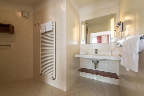 a bathroom with a sink and a mirror at Hotel Tubris Garnì Campo Tures in Campo Tures