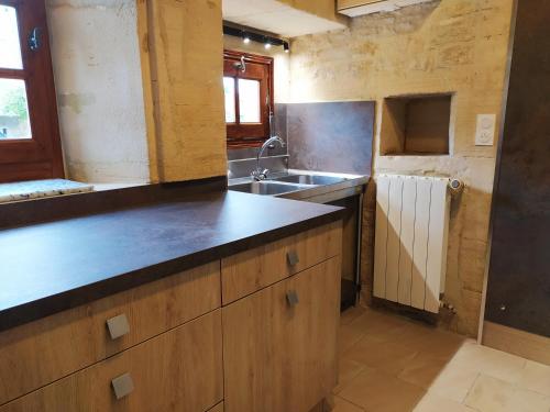 uma cozinha com um lavatório e uma bancada em Appartement Prestige Résidentiel 3 chambres 3 salles de bain au Manoir de Mathan à Crépon 5 mn d'Arromanches et 10 mn de Bayeux em Crépon