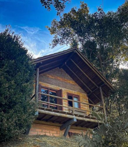a log cabin with a balcony on the side of it at Pousada Aceguá in Praia Grande