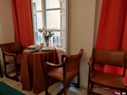 een eetkamer met een tafel en stoelen en een raam bij Principe B in Granada