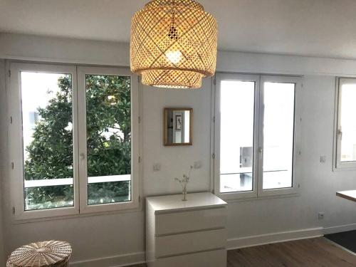 Elle comprend un salon doté de fenêtres et d'un lustre. dans l'établissement Hyper Centre Port La Rochelle, à La Rochelle