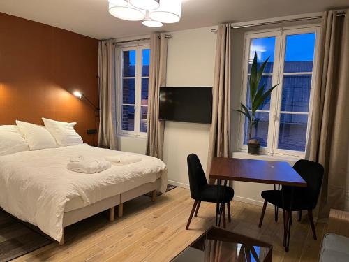 1 dormitorio con 1 cama, escritorio y 2 ventanas en Bella Vita, en Villers-Cotterêts