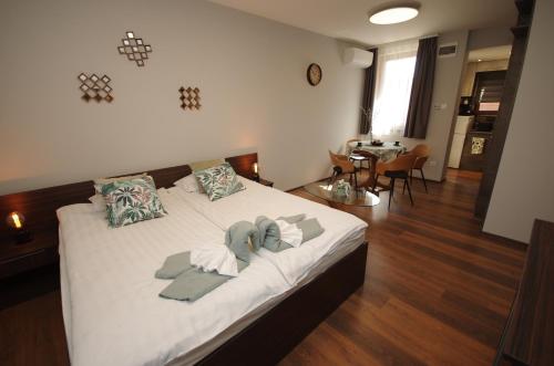 a bedroom with a bed with white sheets and pillows at Paradiso Apartmanház in Gyula