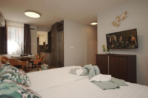 Paradiso Apartmanház في غيولا: غرفة نوم مع سرير وتلفزيون على الحائط