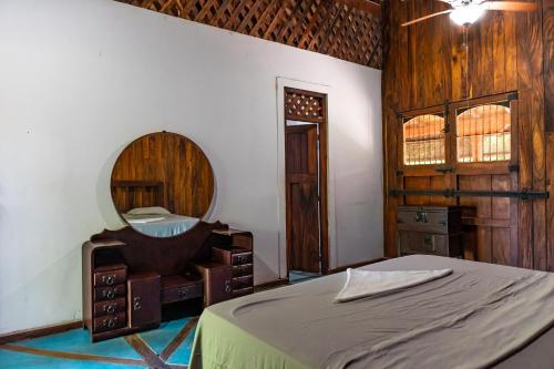 een slaapkamer met een bed en een spiegel bij Casa Hacienda El Menco in Rivas
