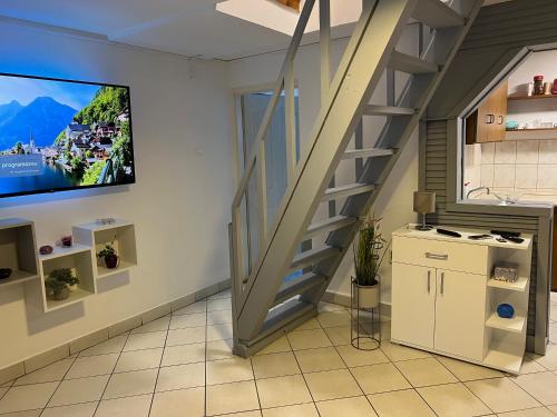 a living room with a staircase and a tv on the wall at Bónom-zugi Pihenőház in Gyomaendrőd