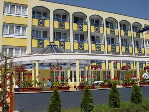 a building with a gazebo in front of it at Hotel Rudolf in Hajdúszoboszló