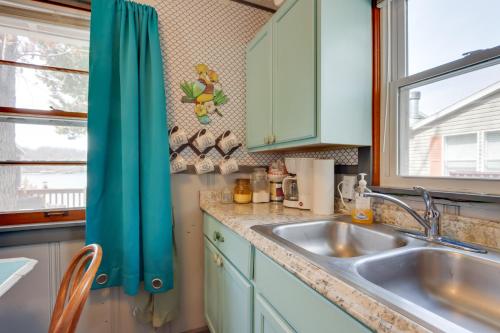 a kitchen with a sink and a window at Cozy Camdenton Cottage with Deck and Boat Dock Access! in Camdenton