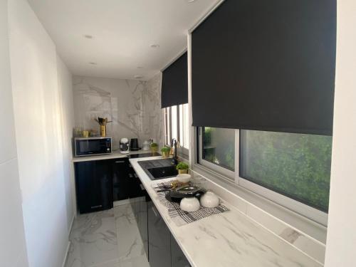 d'une cuisine avec un comptoir, un évier et une fenêtre. dans l'établissement Studio centre ville palais de la mer 100m port et 300m plage, à Sainte-Maxime