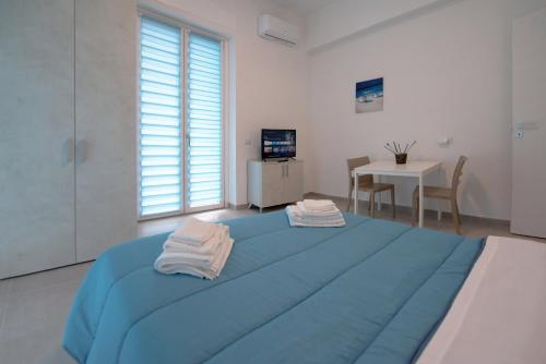 - une chambre avec un lit bleu et des serviettes dans l'établissement Rocciola Home, à Salerne