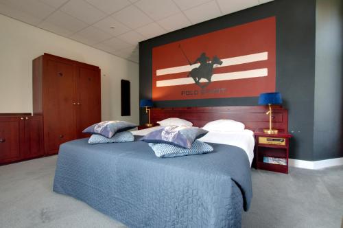 a bedroom with two beds and a painting on the wall at Boetiek Hotel BonAparte Lochem in Barchem