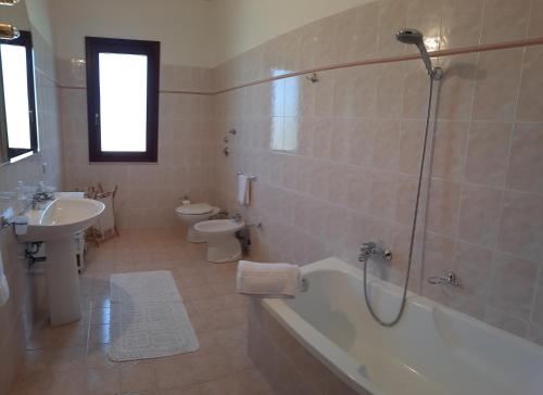 ein Badezimmer mit einer Badewanne, einem WC und einem Waschbecken in der Unterkunft Casa vacanze Tommasone in Custonaci
