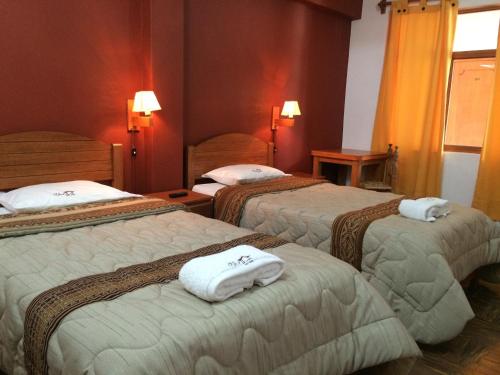 Habitación de hotel con 3 camas y toallas. en El Jacal Classic en Huaraz