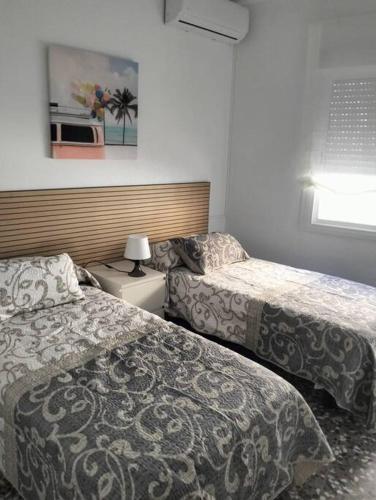 a hotel room with two beds and a lamp at Alojamiento Dunas centro in Tabernas
