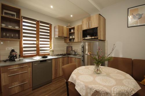a kitchen with a table with a vase on it at Paradiso Apartmanház in Gyula