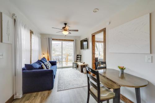 a living room with a table and a blue couch at Hilltop Hideaway with Scenic Views and Hot Tub! in West Jefferson
