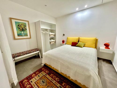 Schlafzimmer mit einem Bett mit gelben und roten Kissen in der Unterkunft Case Orlando_a city center Sicilian treat in Palermo