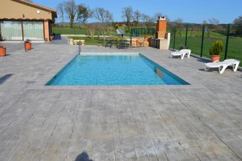 a swimming pool in a patio with a table and chairs at Mas Piua in Girona