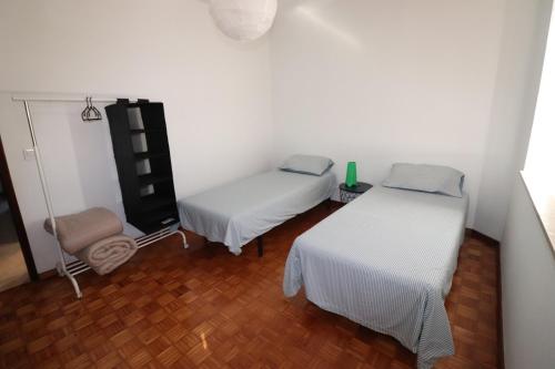 a small room with two beds and a television at T3 Casa Central in Sesimbra